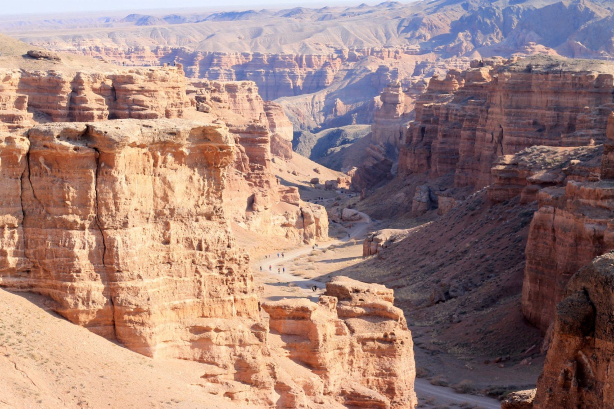 Panorama Kanionu Szaryńskiego w Kazachstanie, porównywanego do Wielkiego Kanionu, z widoczną doliną i ścieżką turystyczną