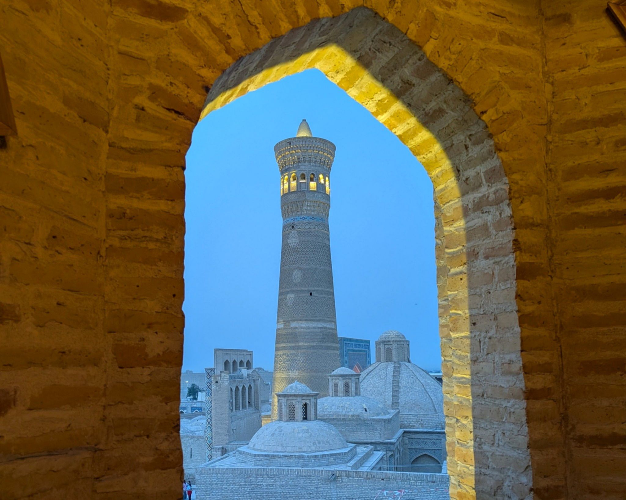 Minaret Kalon w Bucharze widziany przez łuk starej medresy, Uzbekistan