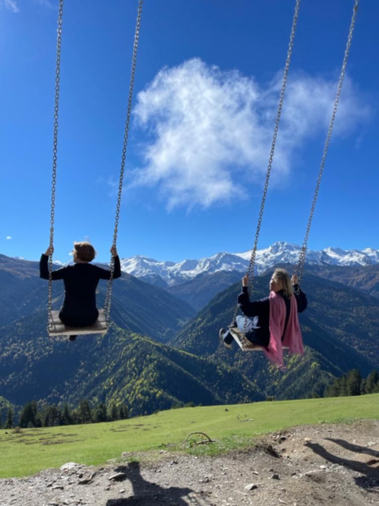 Huśtawki zawieszone nad doliną z panoramicznym widokiem na kaukaskie góry, Gruzja