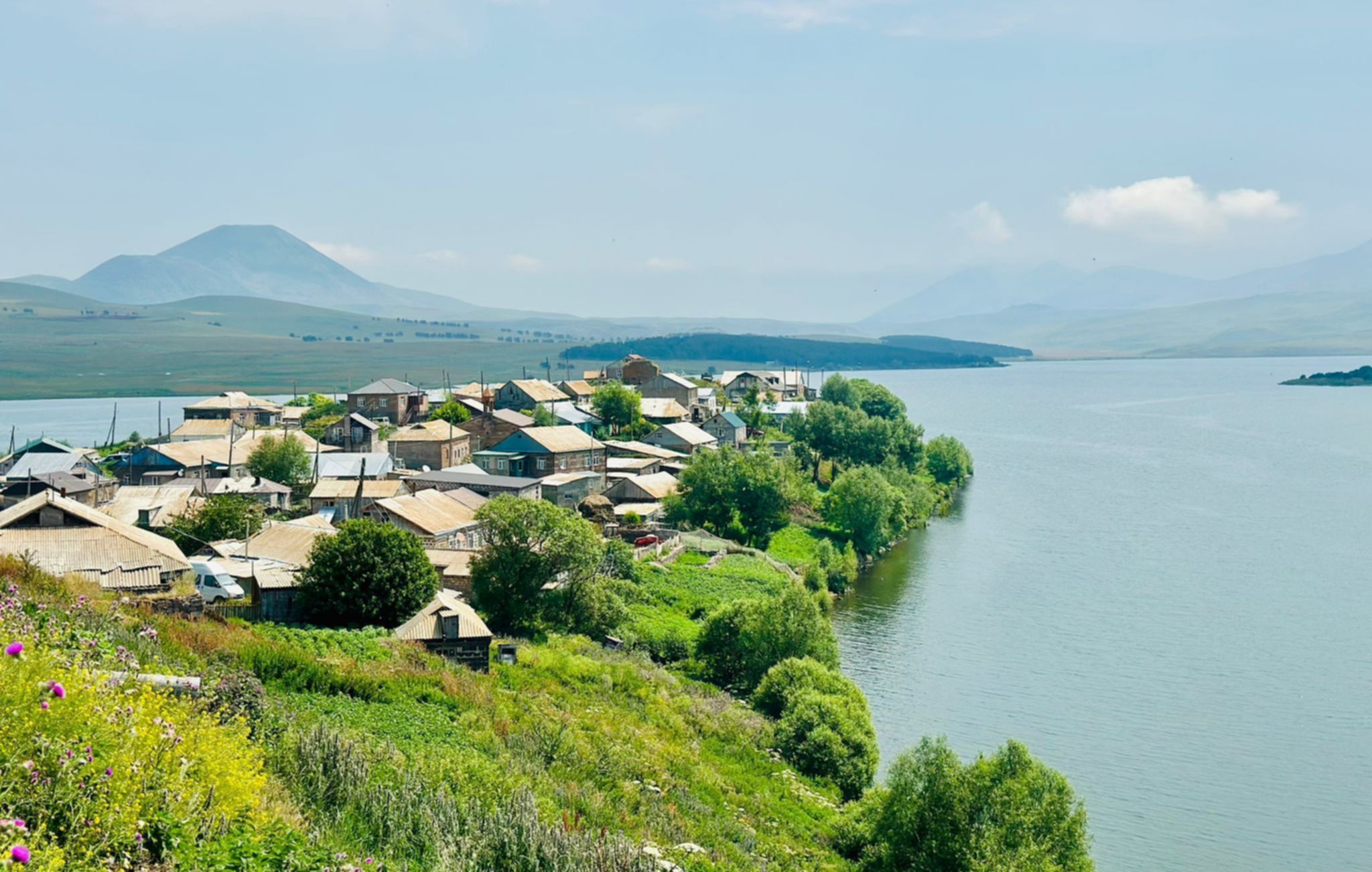 Jezioro Tabatskuri w Gruzji – widok na wioskę nad brzegiem jeziora i zielone wzgórza