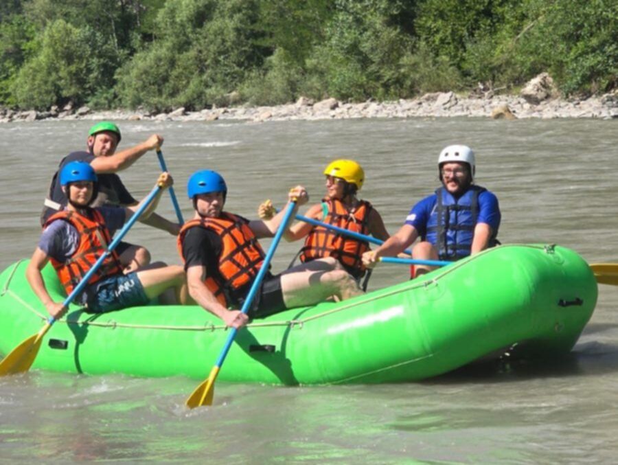 Grupa uczestników raftingu płynąca pontonem górską rzeką w Gruzji, aktywna przygoda wśród zielonych zboczy Kaukazu.